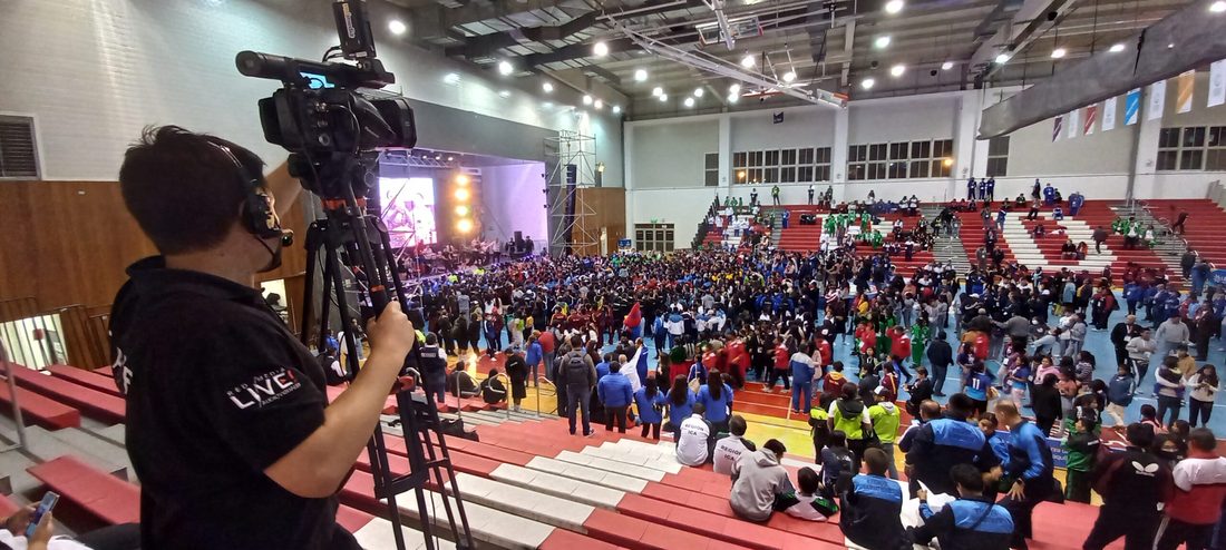 Camarógrafo de RedMediaLive cubriendo evento deportivo multitudinario